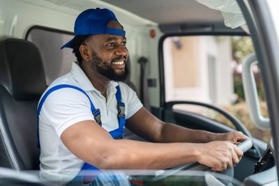 smiling-man-mover-worker-in-blue-uniform-driving-t-2024-11-27-15-39-30-utc.jpg