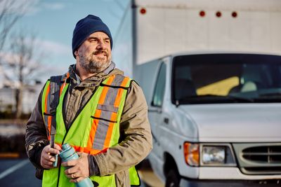 happy-truck-driver-with-backpack-and-water-bottle-2024-12-13-18-34-55-utc.jpg